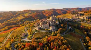 Veduta aerea di un borgo collinare circondato da colline con i colori autunnali