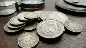 Monete svizzere in argento di diversi tagli su un tavolo in legno